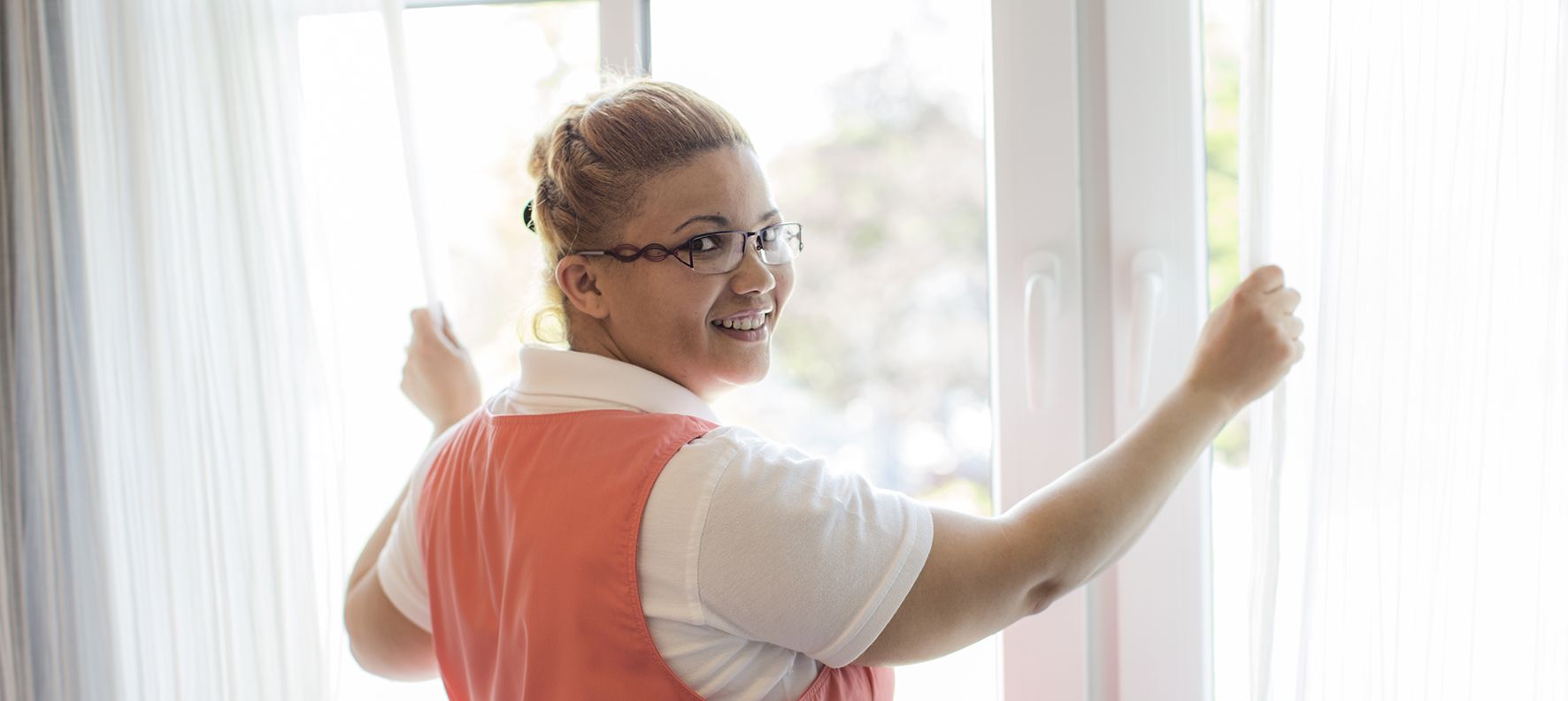 Housekeeper opens the room curtain and looks into the camera