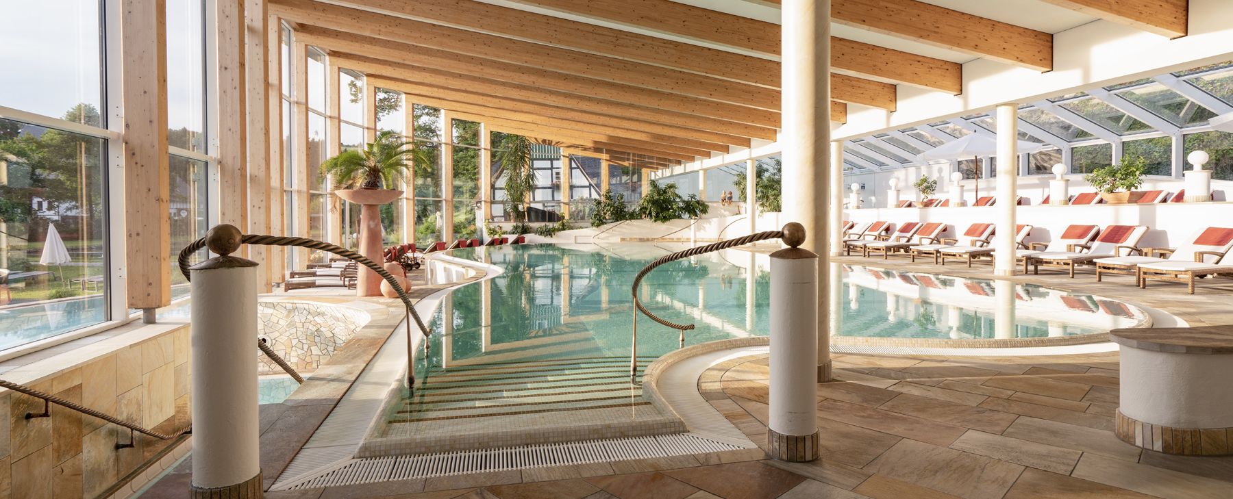 View of the large swimming pool with loungers at Hotel Deimann