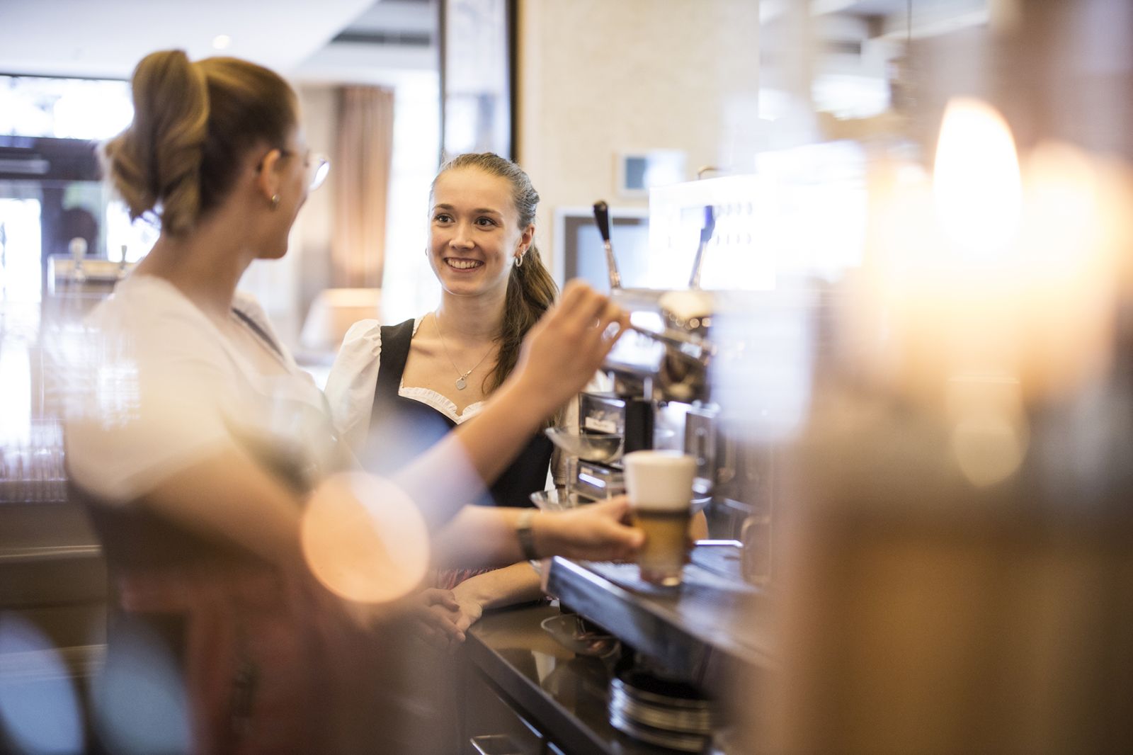 Zwei Servicekräfte an der Kaffeespezialitätenmaschine