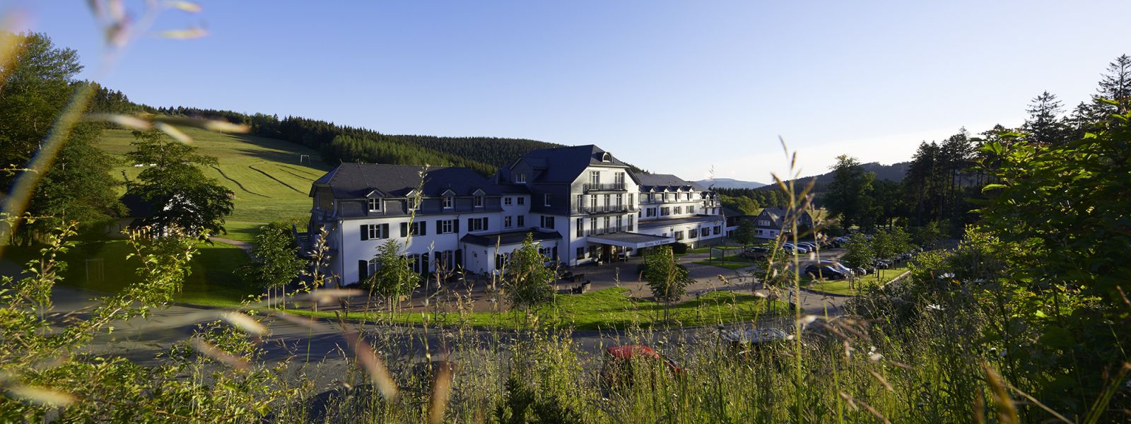 Außenansicht des Hotels, Blick auf den Eingang im Sommer