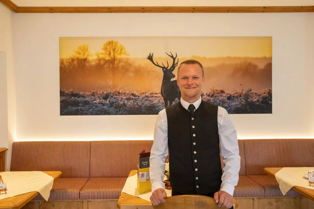 Servicemitarbeiter Chris vom Hotel Voss mit Uniform - weißes Hemd und Weste