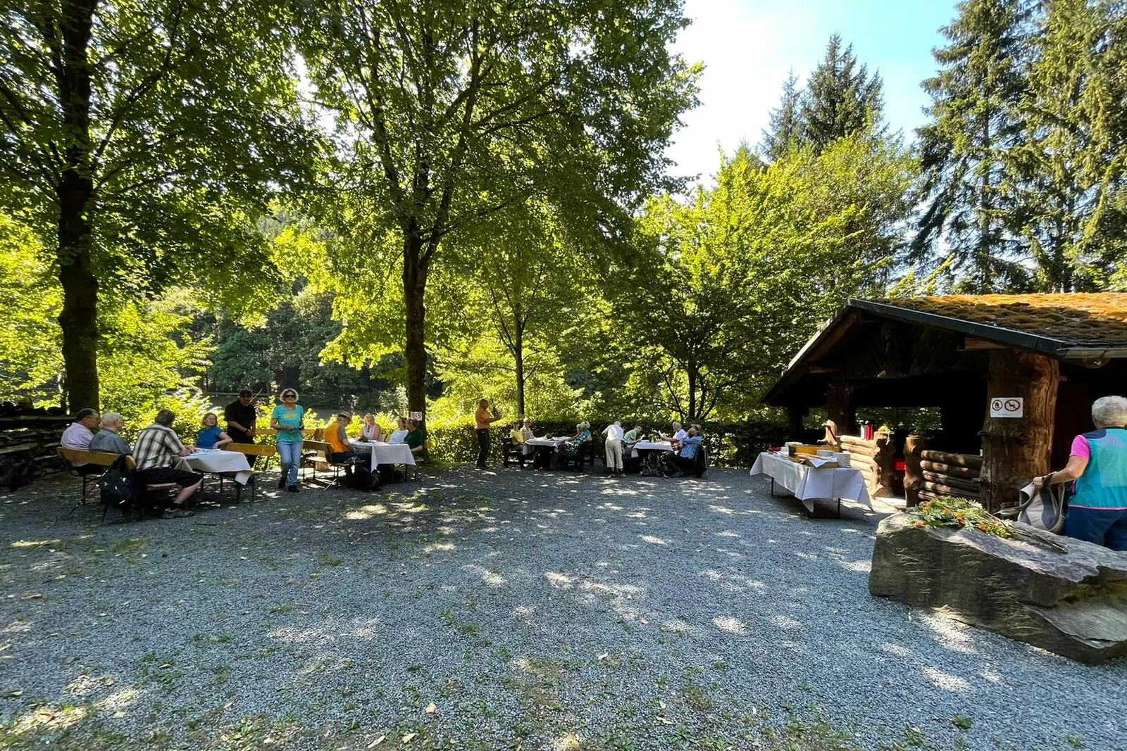 Pause der Wanderer an Schutzhütte mit Bierbänken