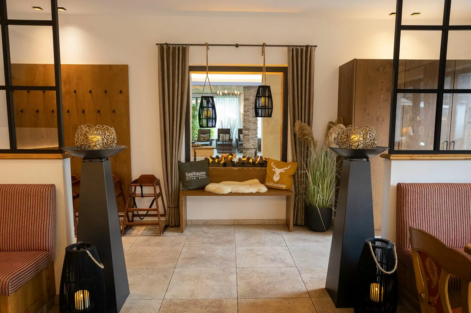 Landhotel Voss – Durchblick Hotel Voss: Deko im Restaurant, Blick auf ein Fester, das in den Poolbereich schaut