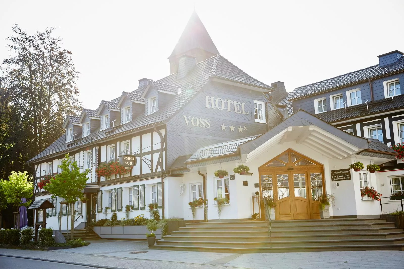 Herzlich Willkommen im Landhotel Voss Außenansicht Hotel Voss mit Sonnenstrahlen