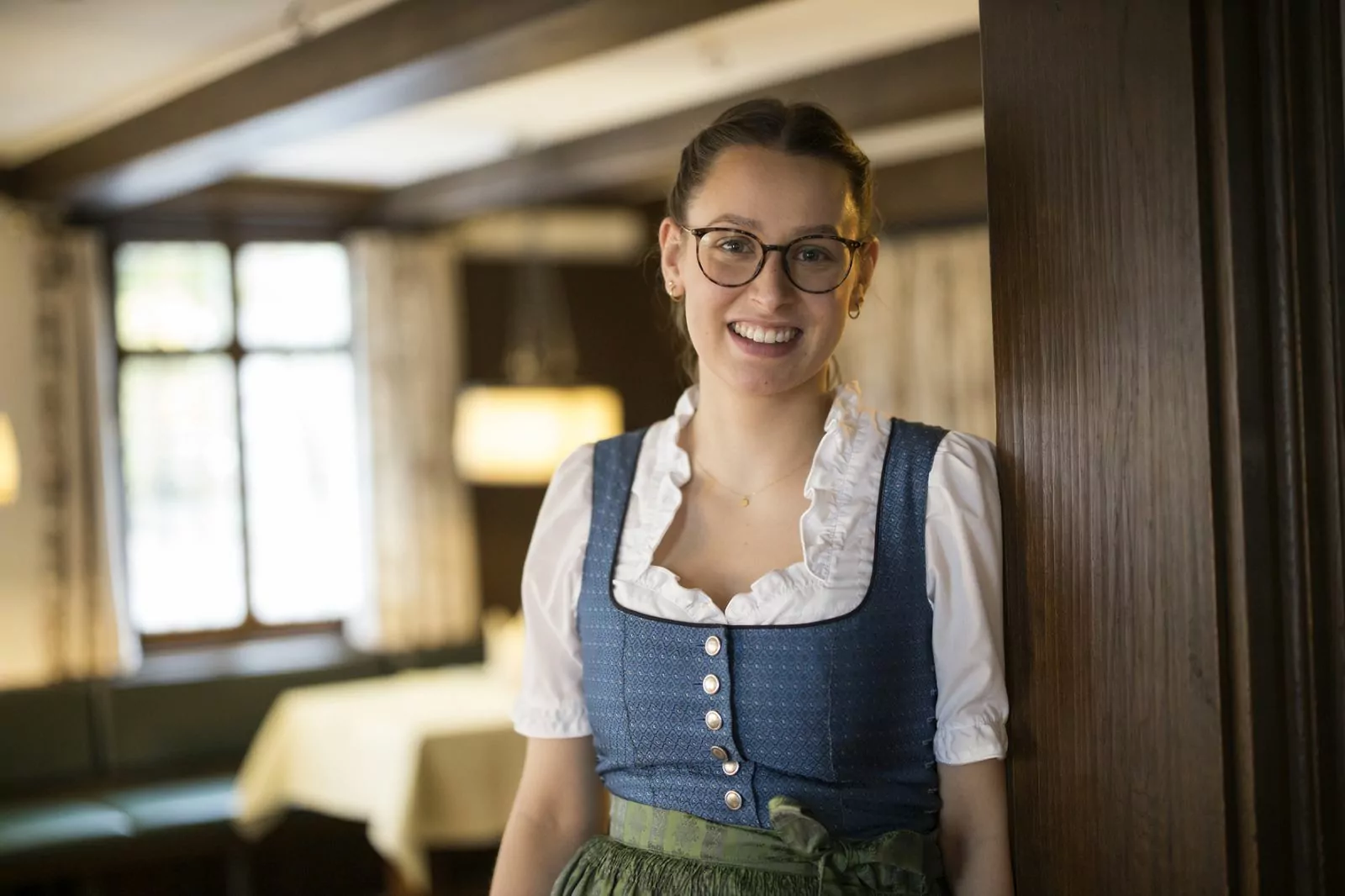 Sterne im Sauerland Nachhaltigkeit Arbeitgeber zufriedene Mitarbeitende Nachhaltigkeit Lächelnde Service-Mitarbeiterin im Dirndl