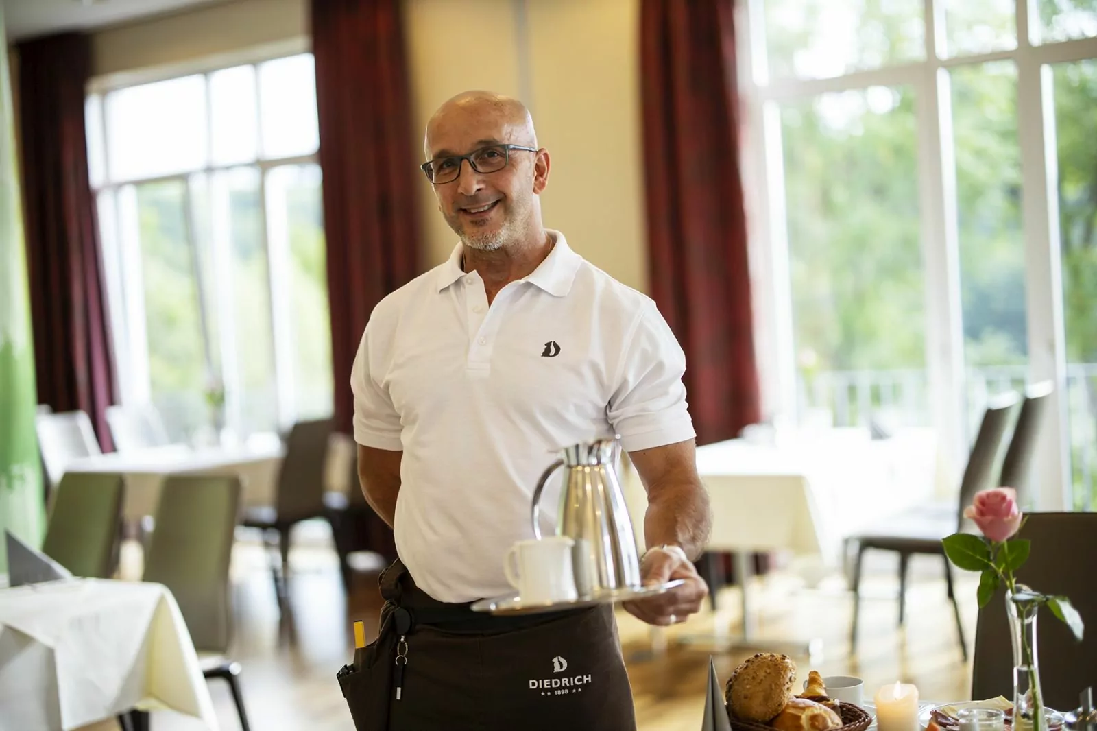 Sterne im Sauerland Nachhaltigkeit Arbeitgeber zufriedener Mitarbeitender Nachhaltigkeit Mitarbeiter im Frühstücksservice serviert Kaffee