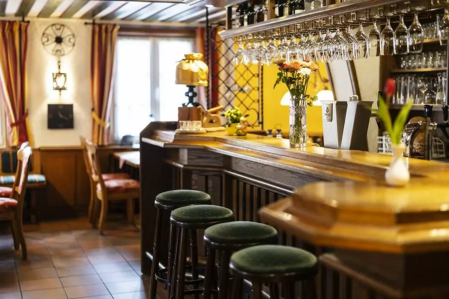 Landhotel Voss – Willkommen zum Thekengespräch rustikaler Bartresen im Hotel Voss mit 4 klassischen Barhockern